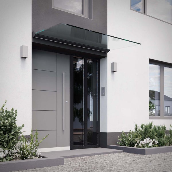 Modernes Haustürvordach aus Glas über einer grauen Eingangstür mit langem silbernem Türgriff.