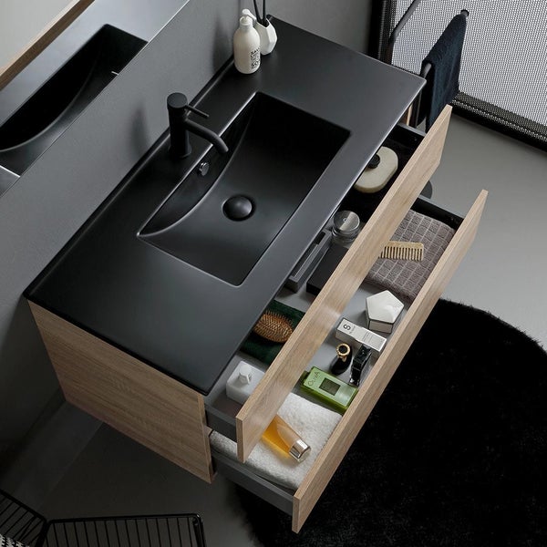 Badezimmer mit Waschbecken, Waschtischunterschrank mit offenen Schubladen und verschiedenen Badutensilien