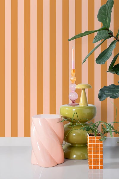 Dekorative Szene mit Möbeln und Pflanzen vor gestreifter Wand