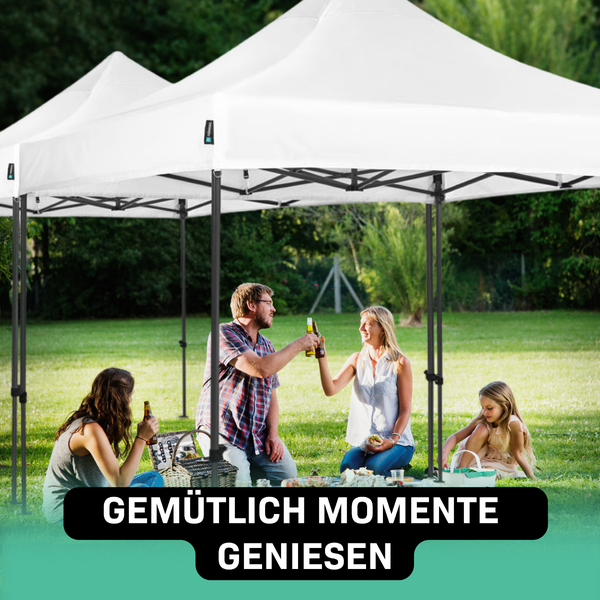 Familie genießt Picknick unter einem weißen Pavillon im Garten.