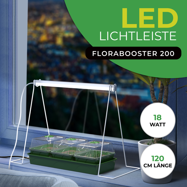 LED Lichtleiste Florabooster 200 für Pflanzen, 18 Watt, 120 Zentimeter Länge, positioniert über Mini Gewächshäusern auf einer Fensterbank.