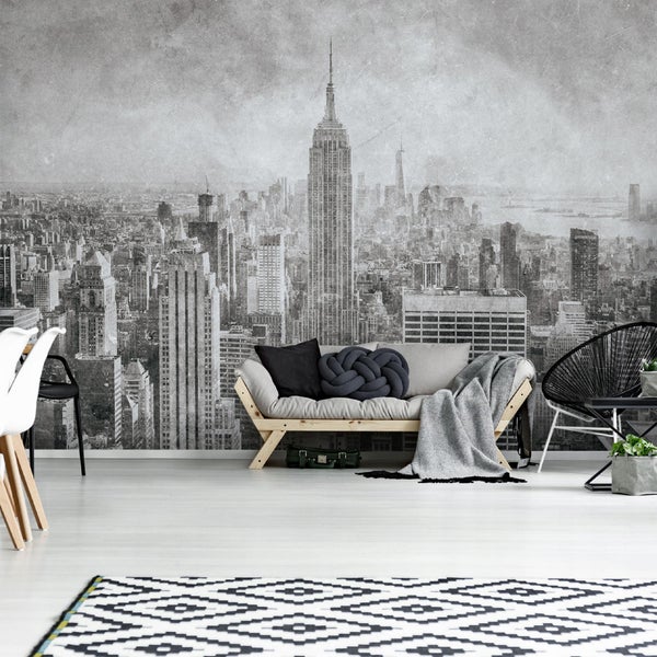 Wohnzimmer mit Fototapete New Yorker Skyline, Sofa, Teppich und Stühlen.