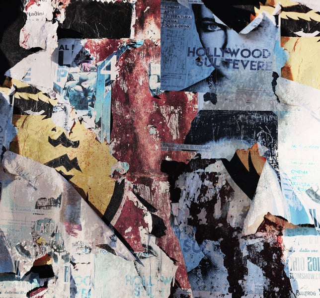 Wand mit abgerissenen Postern, die verschiedene Texte und Bilder zeigen.