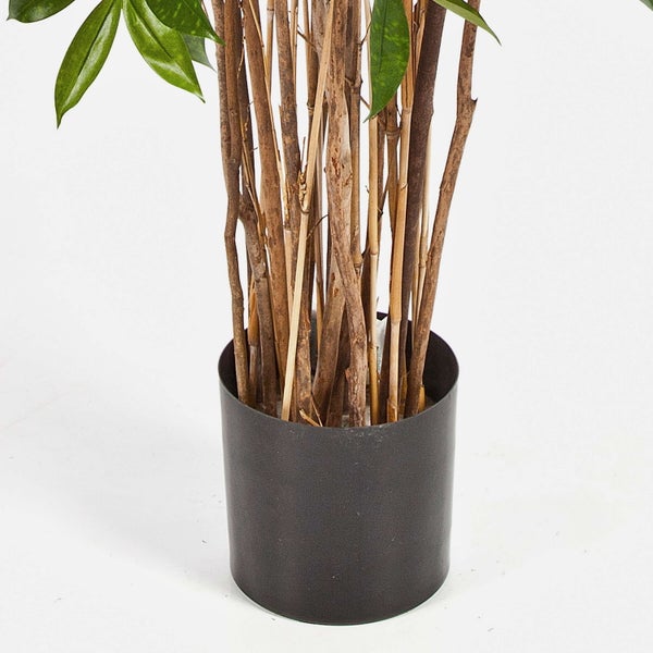 Künstliche Pflanze mit mehreren braunen Stielen in einem dunkelgrauen zylindrischen Topf und grünen Blättern.