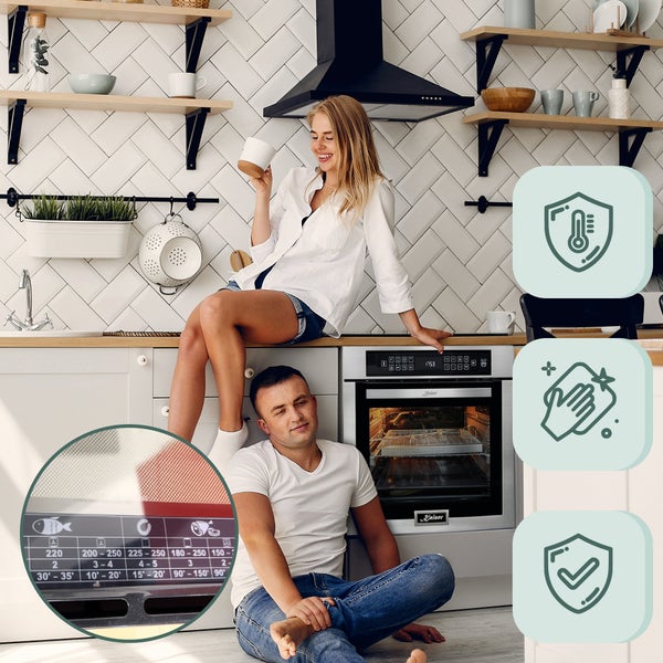 Ein Paar in einer modernen Küche mit einem Einbau-Backofen. Symbole für Wärmeschutz, leichte Reinigung und allgemeine Zertifizierung.