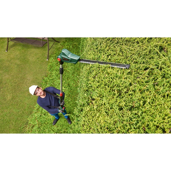 Mann schneidet eine hohe Hecke mit einer Bosch Teleskop-Heckenschere im Garten.