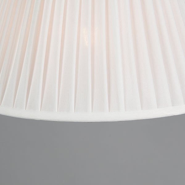 Detailansicht eines plissierten Lampenschirms aus weißem Stoff.
