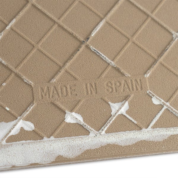 Rückseite einer Fliese mit Gitterstruktur und eingeprägtem Herkunftshinweis Made in Spain.