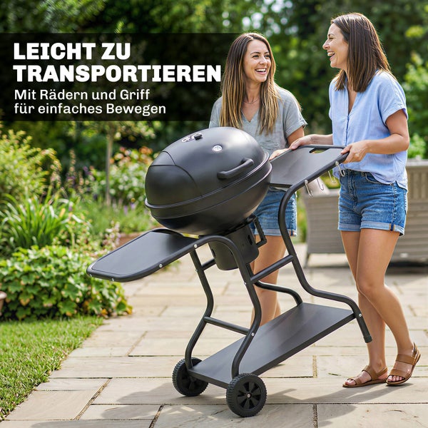Zwei Personen transportieren einen schwarzen Kugelgrill mit Rädern und Handgriff auf einem gepflasterten Weg im Garten.