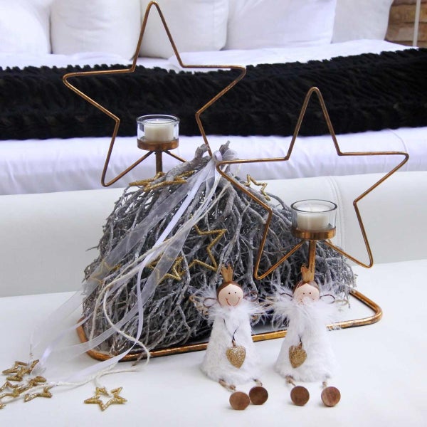 Dekoratives Arrangement mit Sternen, Kerzen, Zweigen und Figuren für die festliche Jahreszeit