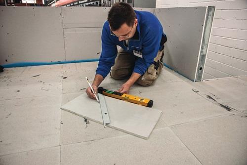 Mann mit Wasserwaage bei Bauarbeiten im Rohbau