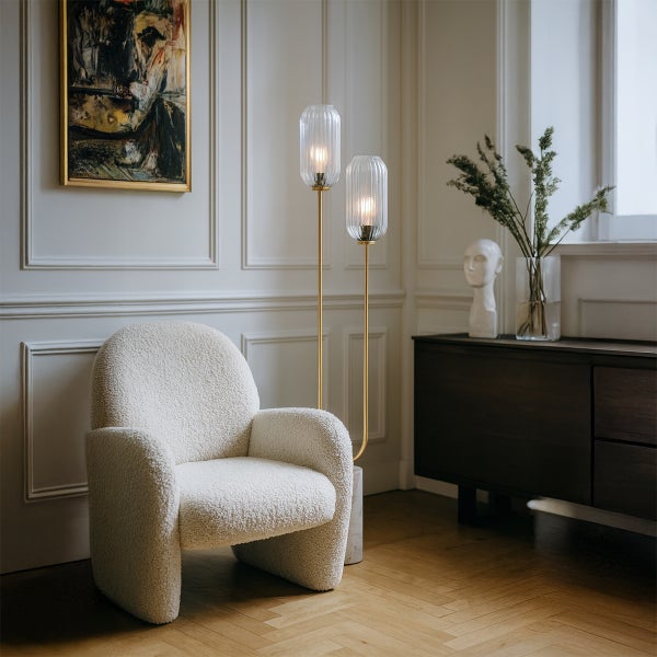 Wohnzimmer mit Sessel, Stehlampen und Sideboard