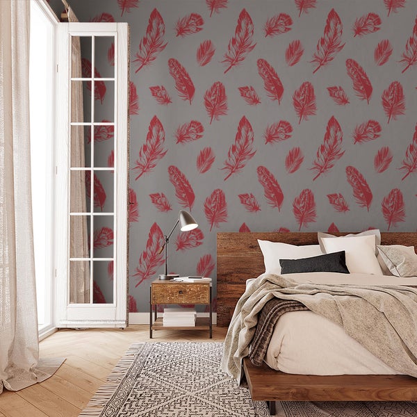Schlafzimmer mit Mustertapete mit Federmotiv, Holzbett, Nachttisch mit Lampe und Parkettboden.