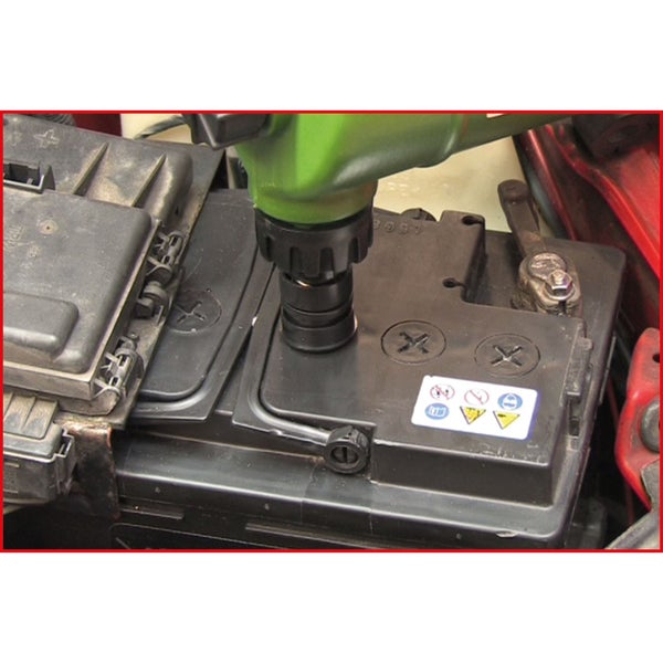 Eine Autobatterie wird mit einem Werkzeug gewartet, das in eine der Öffnungen eingesetzt wird, um Flüssigkeit nachzufüllen.