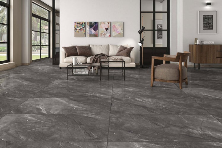 Wohnzimmer mit grauen Bodenfliesen in Marmoroptik, Sofa, Tisch und Stuhl.