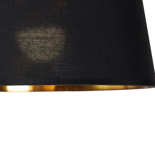 Detailansicht eines Lampenschirms mit schwarzem Stoff und goldenem Innenfutter