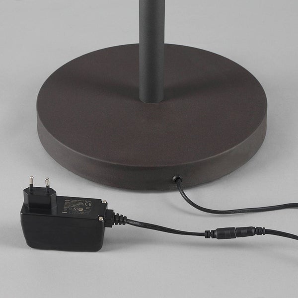 Runder Lampenfuß aus Metall mit schwarzem Netzteil und Kabel.
