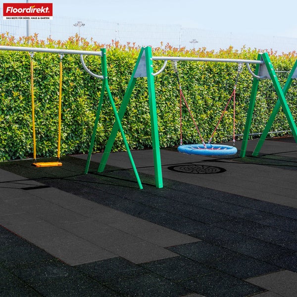 Floordirekt Logo. Fallschutzmatten aus Gummi auf einem organisierten Spielplatz mit Schaukeln und einer Hecke im Hintergrund.