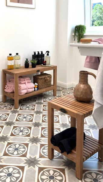 Badezimmer Szene mit Holzregal, Hocker und dekorativen Elementen auf gemusterten Fliesen