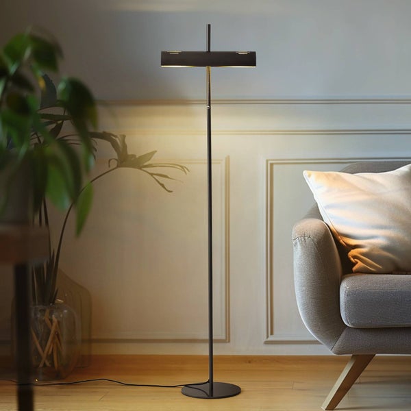 Stehleuchte im Wohnzimmer neben einem Sessel und einer Pflanze