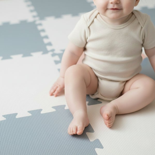 Baby sitzt auf einer Puzzle-Spielmatte aus Schaumstoff mit strukturierter Oberfläche.