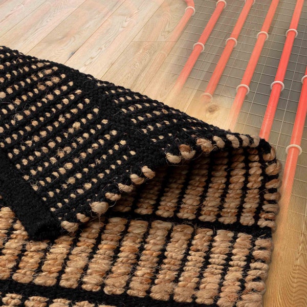 Teppich aus Jute und Baumwolle auf Holzboden mit sichtbarer Fußbodenheizung.