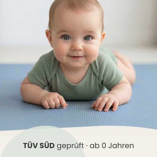 Baby liegt auf einer strukturierten Spielmatte, TÜV SÜD geprüft und ab null Jahren geeignet.