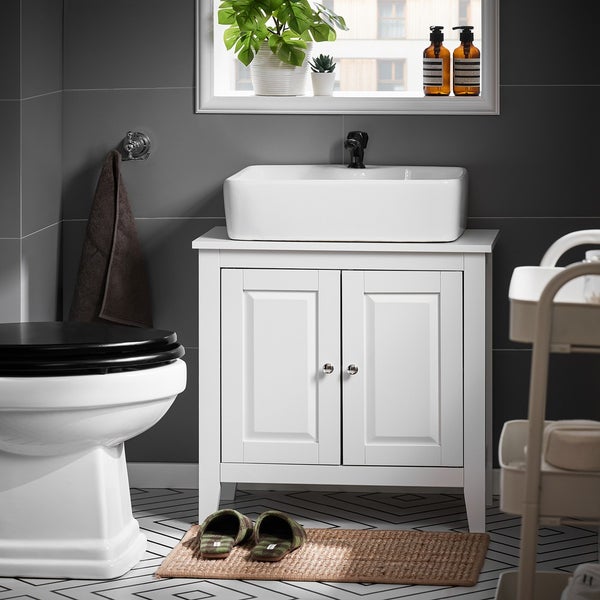 Badezimmer mit Waschtischunterschrank, Waschbecken, Toilette und Badaccessoires in einem hellen und organisierten Raum.