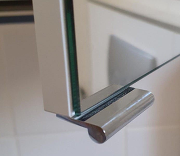 Detailansicht eines Spiegelschrankes mit Glasablage und Metallhalterung