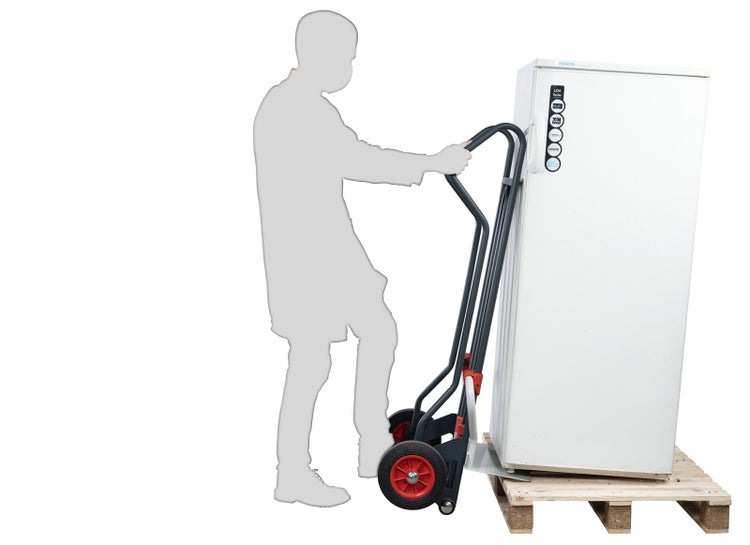 Schwarze Transportkarre mit roten Rädern beim Transport eines Kühlschranks von einer Holzpalette mit Personensilhouette.