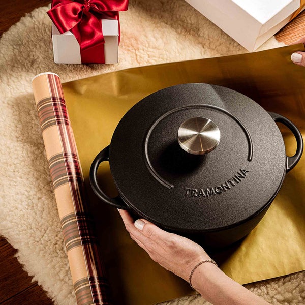 Schwarzer Schmortopf von Tramontina wird verpackt, Geschenkpapier und Geschenkbox sind zu sehen.