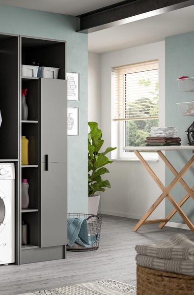 Organisierte Waschküche mit grauem Hochschrank, Waschmaschine, hölzernem Bügelbrett und Zimmerpflanze. Hell und moderner Hauswirtschaftsraum.