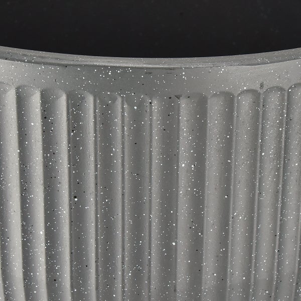 Detailansicht eines geriffelten Pflanzgefäßes mit gesprenkelter Oberfläche.