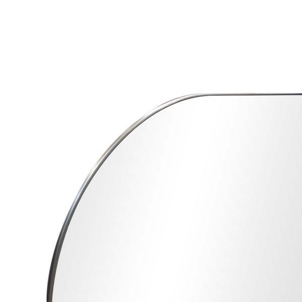 Detailansicht einer abgerundeten Ecke eines Spiegels mit dünnem Metallrahmen.