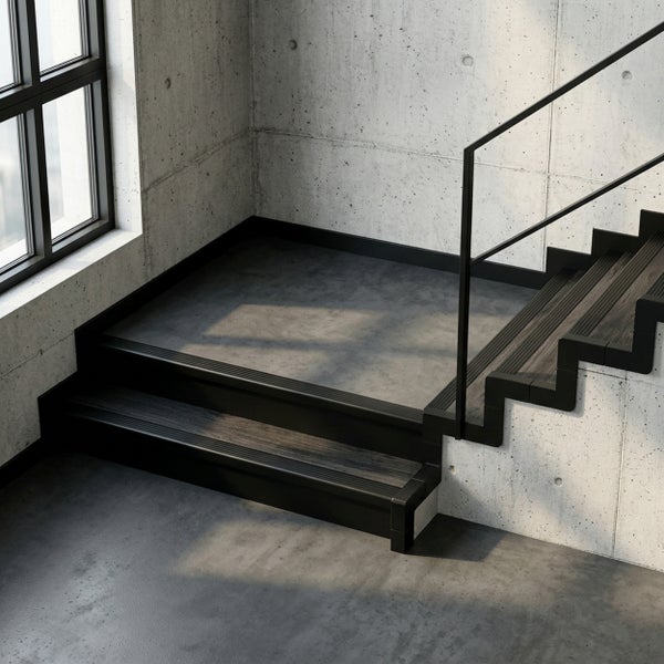 Treppe im industriellen Stil mit dunklen Holzstufen, schwarzen Treppenkantenprofilen und schwarzem Geländer vor Wänden in Sichtbeton-Optik.