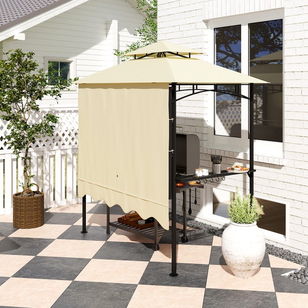 Moderner Grillpavillon mit zweistufigem Dach und Seitenwand auf einer hellen Terrasse neben einem hellen Steinhaus.