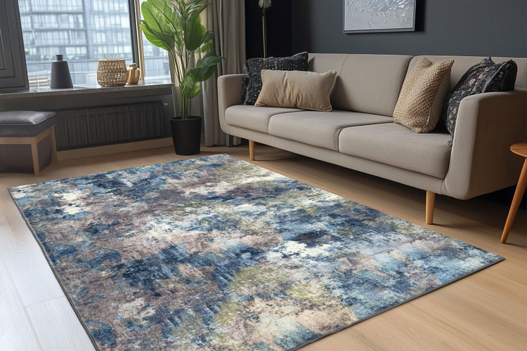 Moderner Wohnzimmerteppich mit abstraktem Muster in einem hellen Wohnbereich mit Sofa und Pflanze.