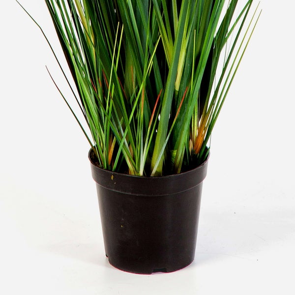 Künstliche Monstera-Pflanze in Nahaufnahme mit grünen, geschlitzten Blättern und sichtbaren Blattadern.