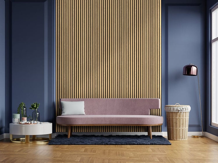 Wohnzimmer mit vertikalen Holzlatten an der Wand hinter einem Sofa, gerahmt von dunklen Wänden und einem runden Beistelltisch.
