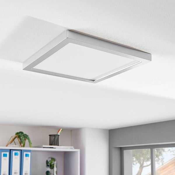 Quadratische LED-Deckenleuchte mit silbernem Rahmen, flach an einer weißen Zimmerdecke in einem hellen Büro montiert.