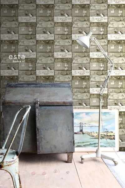 Dekoratives Zimmer mit Koffertapete, Stehlampe und Metallschrank