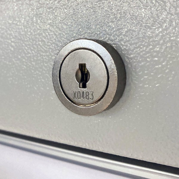 Rundes Zylinderschloss aus Metall für Möbel mit eingravierter Nummer.