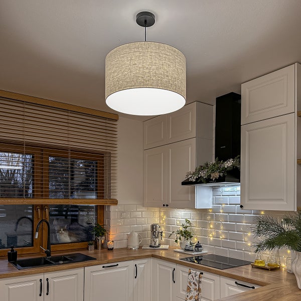 Pendelleuchte mit rundem Textilschirm in Leinenoptik in einer hellen, modernen Küche mit weißen Schränken und Holz-Arbeitsplatte.