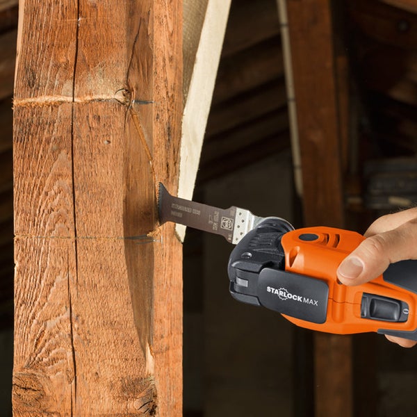 Oszillierendes Elektrowerkzeug beim Schneiden eines Holzpfostens