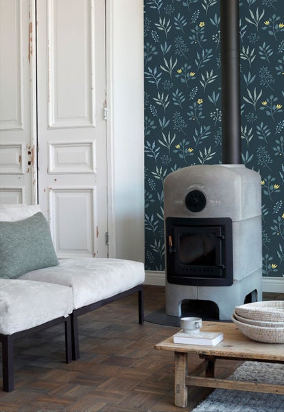 Wohnzimmer mit floral gemusterter Tapete, Ofen und Sitzmöbeln