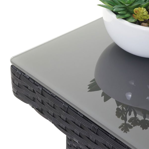 Detailansicht eines Gartentisches mit Glasplatte und Rattanstruktur