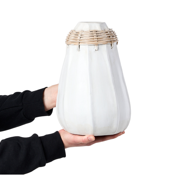 Dekorative Vase aus Keramik mit Rattandekor am Hals gehalten von einer Person.