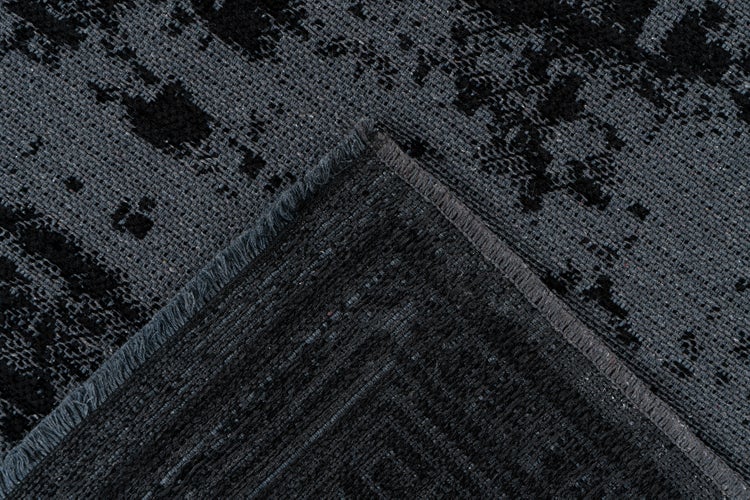 Rechteckiger Teppich in Dunkelgrau mit geometrischer Mäander-Bordüre und meliertem Muster.