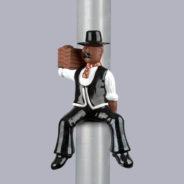 Dekofigur Dachdecker in schwarzer Zunftkleidung, auf einer Stange sitzend und Dachziegel tragend.
