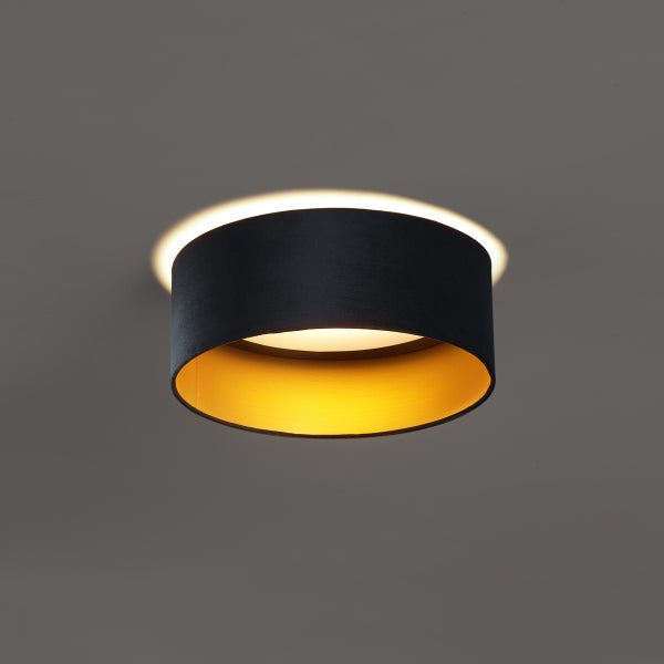 Runde Deckenleuchte mit schwarzem Stoffschirm und goldener Innenseite, eingeschaltet mit warmem Lichteffekt.